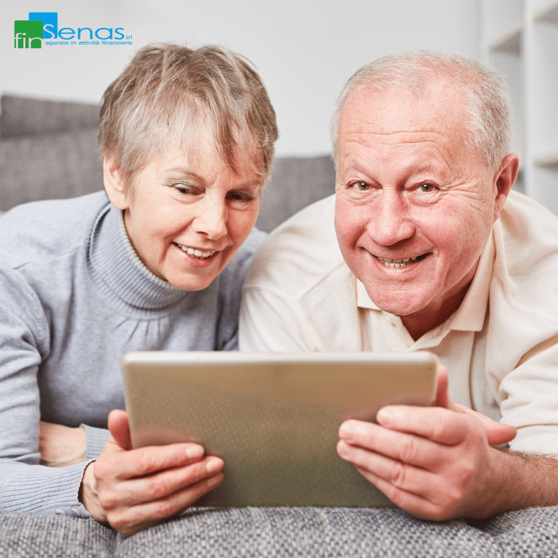 Campagna RED 2025 guida completa per i pensionati su bonus e dichiarazione redditi (1) Coppia di pensionati sorridenti che guarda insieme un tablet, seduta su un divano