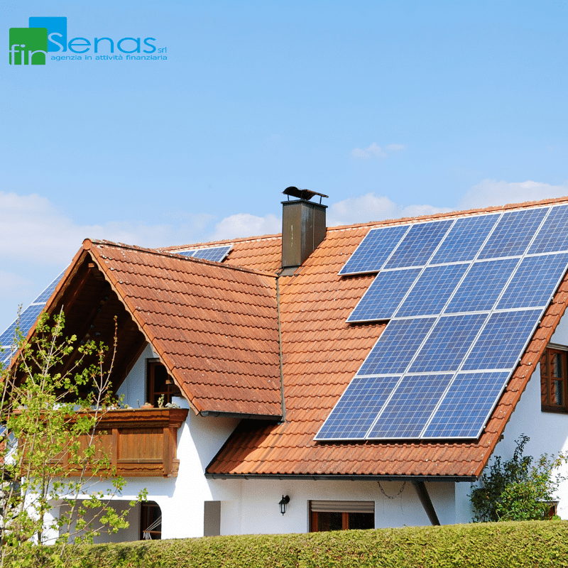 Fotovoltaico domestico vantaggi economici e fiscali Casa con tetto in tegole rosse su cui sono installati pannelli fotovoltaici sotto un cielo sereno