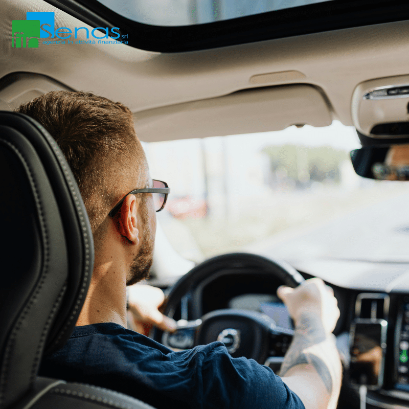 Bollo auto e assicurazione RCA bisogna pagare anche se il veicolo non viene utilizzato Uomo alla guida di un’auto visto dall’interno dell’abitacolo, simbolo dei costi legati a bollo e assicurazione del veicolo.