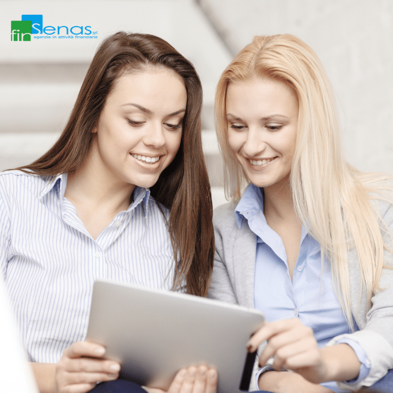 Si può fare una seconda cessione del quinto Tutte le soluzioni Due donne sorridenti consultano un tablet insieme, simbolo di confronto e valutazione di soluzioni finanziarie come la cessione del quinto.
