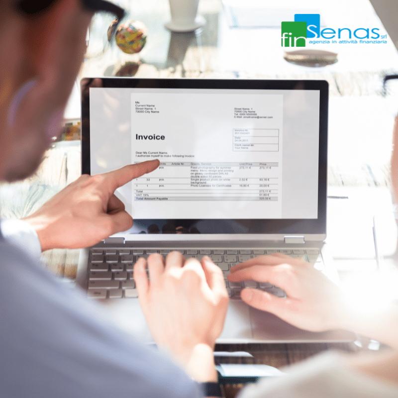 Persone esaminano una fattura sul laptop, simbolo di un’azienda che cerca di ottenere finanziamenti bancari.