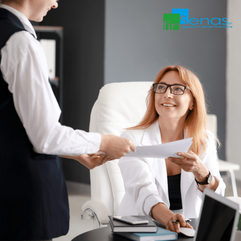 Certificato di stipendio per la cessione del quinto guida completa per dipendenti e aziende Donna in ufficio riceve un documento da un collega, immagine rappresentativa della procedura per ottenere il certificato di stipendio necessario alla cessione del quinto.