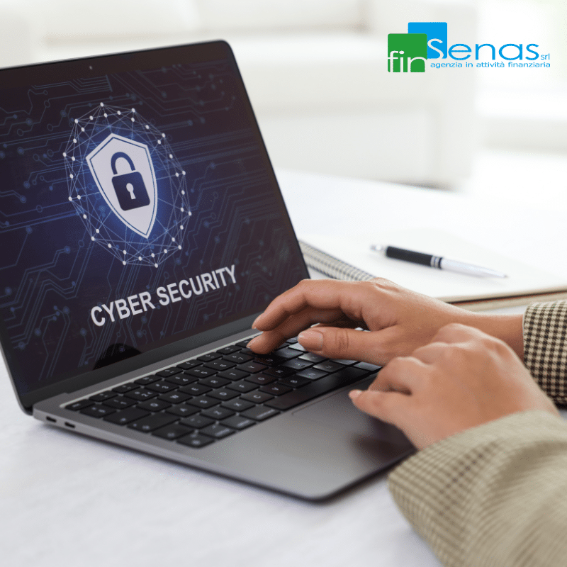 Cyber Security aziendale tutto quello che le aziende devono sapere Persona che utilizza un computer portatile con schermata dedicata alla cyber security e icona di sicurezza digitale, immagine illustrativa sulla protezione informatica aziendale.