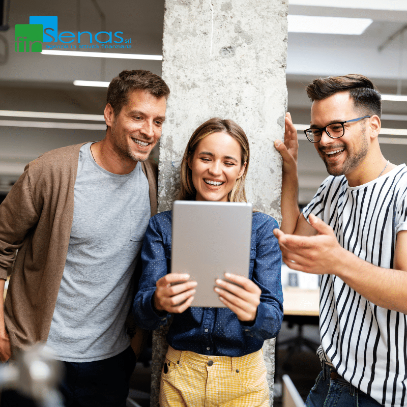 Locazione operativa piccoli canoni, grandi vantaggi per le aziende Tre giovani professionisti osservano un tablet in ufficio, immagine rappresentativa della locazione operativa e delle soluzioni tecnologiche per aziende.