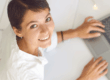 Donna al computer sorride mentre valuta soluzioni di prestito finalizzato e non finalizzato.