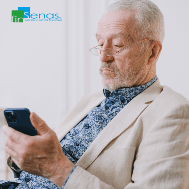 Prestiti ai pensionati la delega di pagamento è ammessa Pensionato consulta il cellulare seduto, riflettendo sulle modalità di pagamento di un prestito.