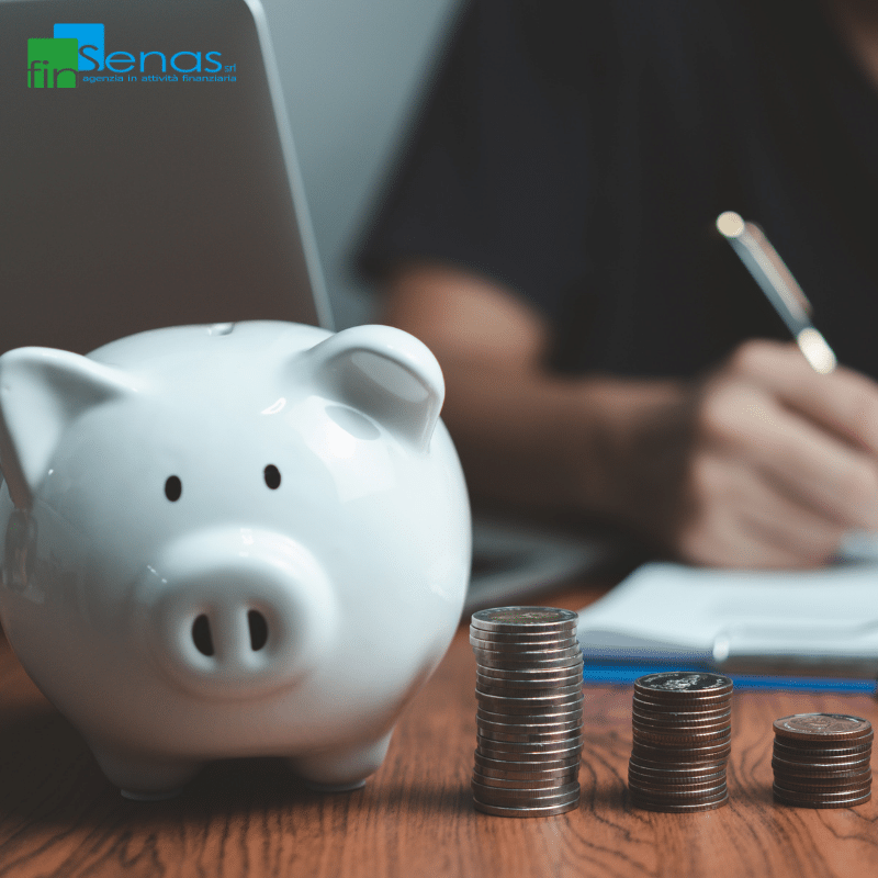 Pensione di reversibilità 2026 beneficiari, percentuali e limiti di reddito Salvadanaio bianco con monete accanto a documenti e penna, rappresentando la gestione economica e gli aspetti previdenziali della pensione di reversibilità.