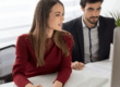 Due persone analizzano documenti finanziari davanti a un computer durante una consulenza, rappresentando la valutazione consapevole di un prestito personale.