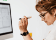 Professionista al computer con una penna in mano, rappresentativa di una persona che valuta con attenzione le condizioni e i vantaggi della Cessione del Quinto.