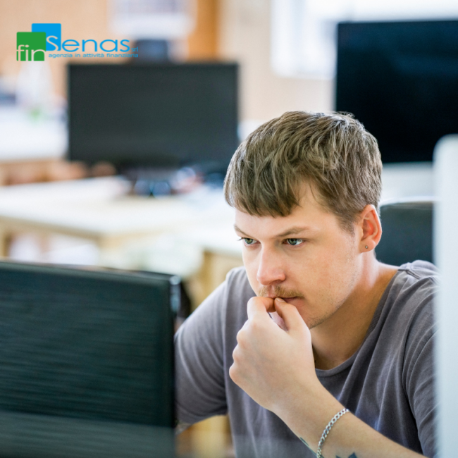 Pignoramento dello stipendio quando valutare la cessione del quinto come soluzione alternativa Uomo preoccupato davanti al computer in ufficio, rappresentativo di una situazione di difficoltà economica legata al pignoramento dello stipendio e alla ricerca di una soluzione finanziaria.