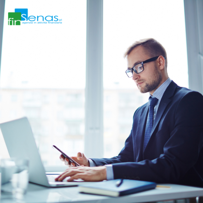 Cessione del quinto la finanziaria contatta il datore di lavoro Professionista al computer utilizza lo smartphone durante un’attività lavorativa, rappresentando i contatti tra finanziaria e datore di lavoro nella Cessione del Quinto.